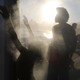 People cool off at a cooling station on a hot winter day on Ipanema beach.