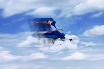 A man relaxing on a plane seat hovering among clouds in a blue sky