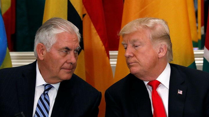 Donald Trump and Rex Tillerson are seated next to each other