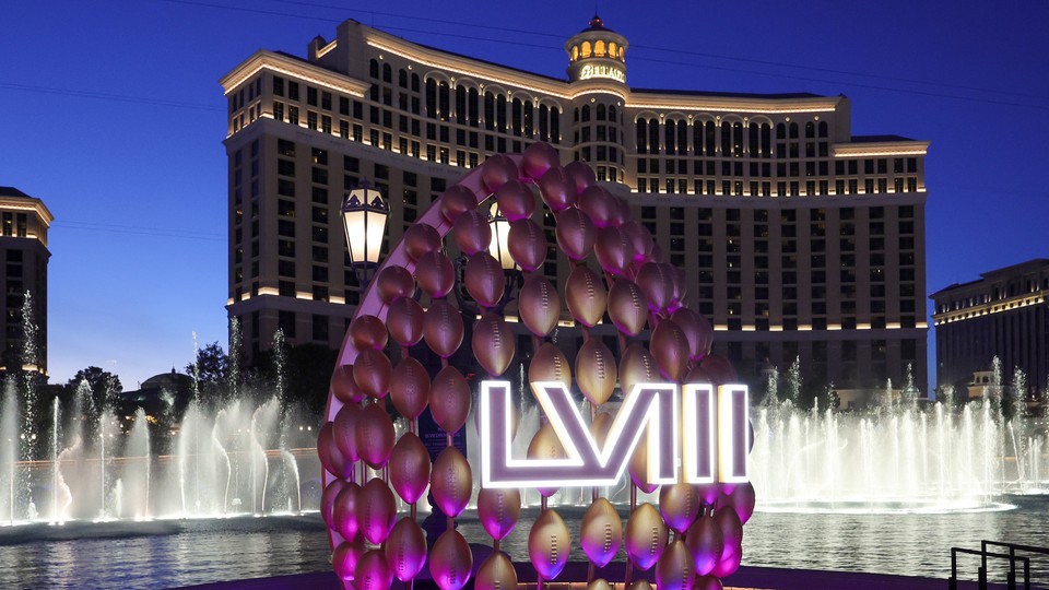 A display of footballs with a Super Bowl LVIII logo in front of the fountains of Bellagio