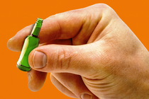 Photo of a hand holding a mini bottle of beer