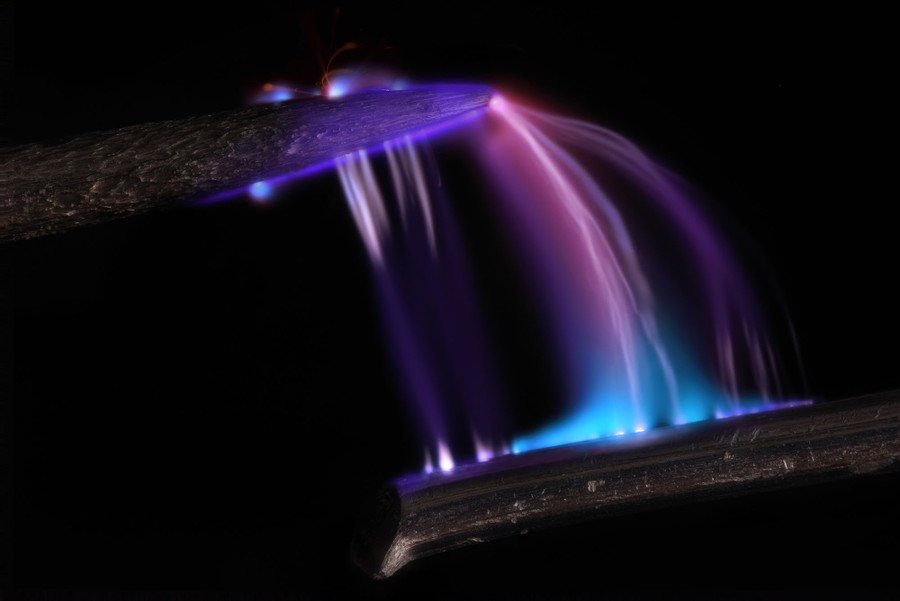 Purplish arcs of plasma leap from a wire to the tip of a needle.