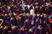 Tsinghua University graduates attend their commencement ceremony in caps and gowns.
