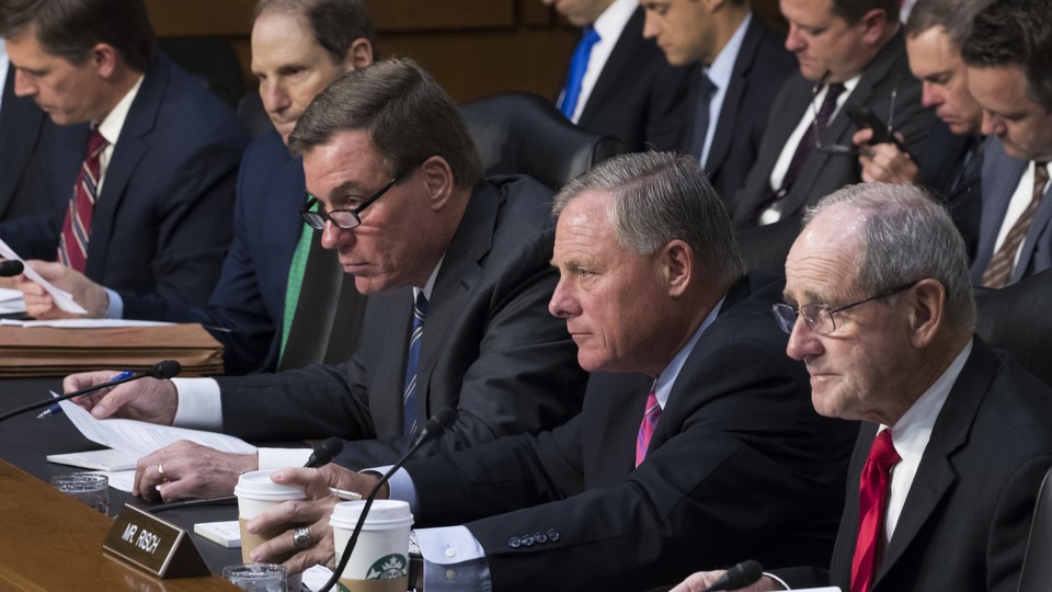 Five men from the Senate Intelligence Committee sit at a desk