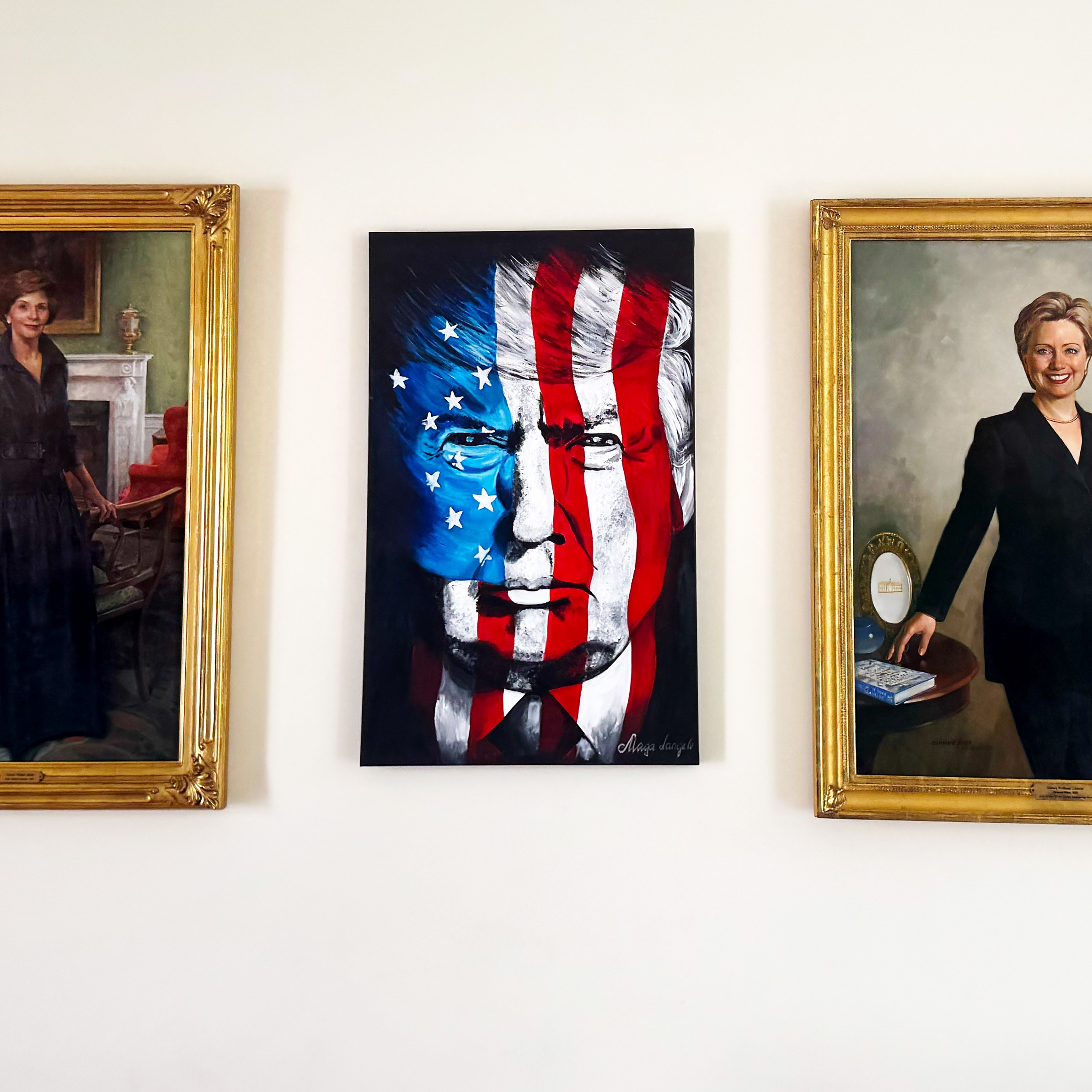 a painting of donald trump between paintings of first Lady Laura Bush and Hilary Clinton