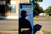 The shadow of a man over a mailbox