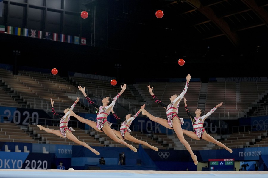 A rhythmic gymnastics team performs with balls.