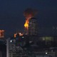 Flames are visible in a night sky behind a high-rise in Kyiv.