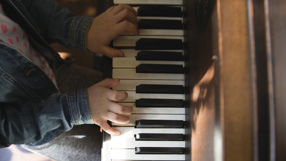 The hands of a young child playing the piano