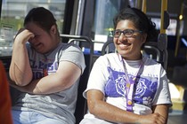 Two women smile on a public bus