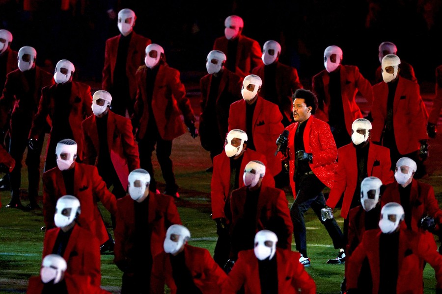 The performer the Weeknd moves among dozens of identically masked dancers.