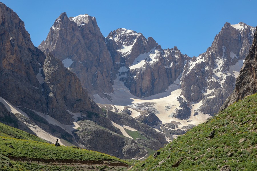 A person poses for a photo in a high mountain valley.