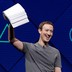 Mark Zuckerberg holds a stack of papers aloft, against a blue background.