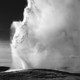A black and white photograph of Old Faithful geyser erupting in Yellowstone National Park, Wyoming, between 1941 and 1942