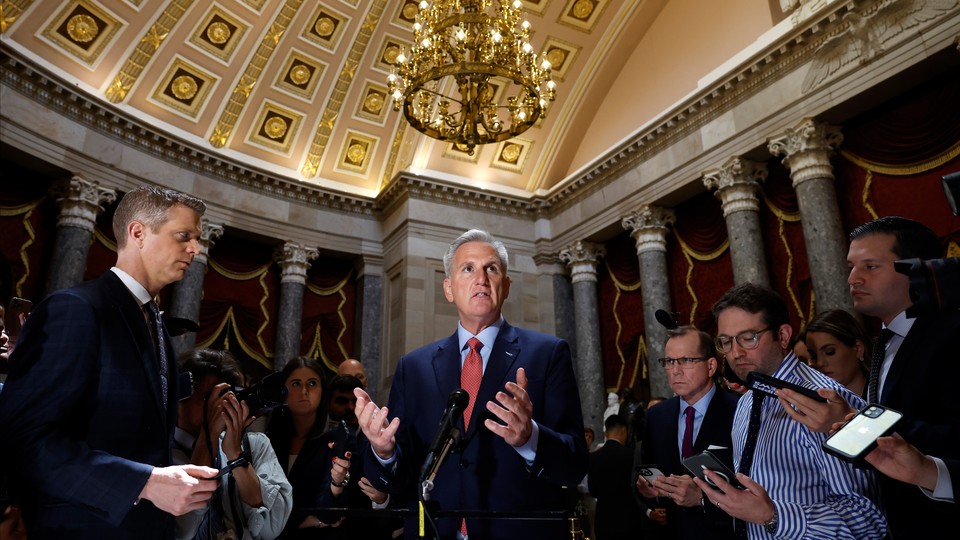 Kevin McCarthy speaks to reporters while standing under a chandelier.