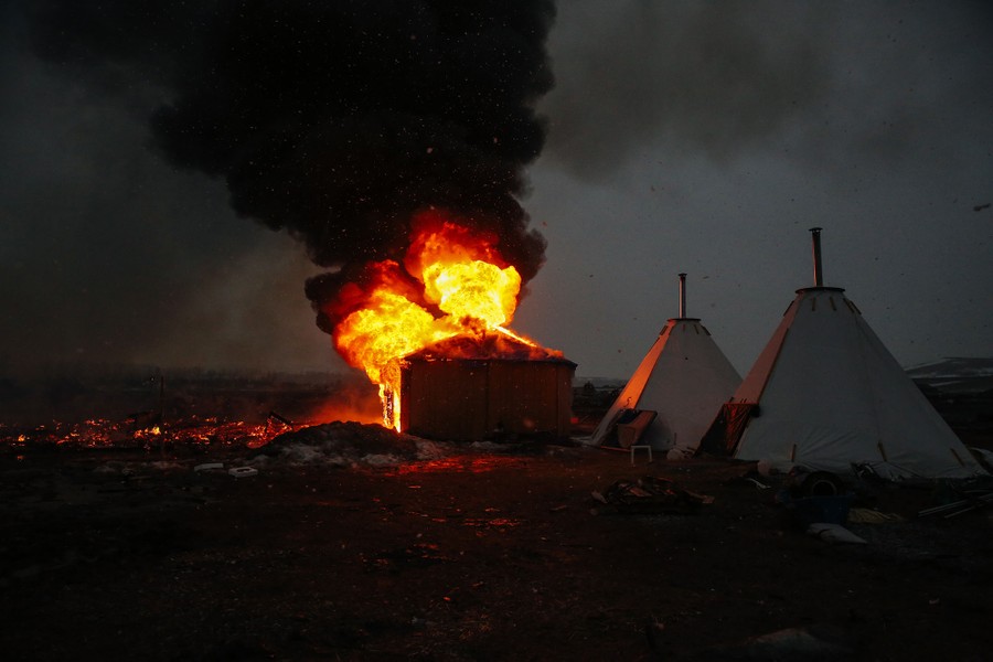 Campers set structures on fire in preparation of the Army Corp's 2 p.m. deadline to leave the Oceti Sakowin protest camp on February 22, 2017.