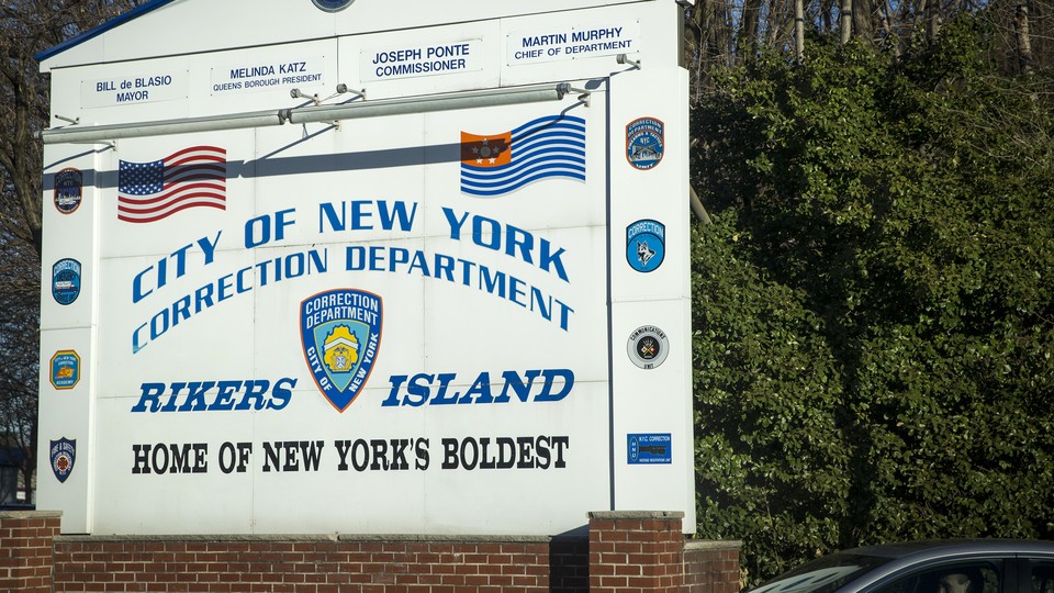 A sign reading "City of New York Correction Department: Rikers Island, Home of New York's Boldest"