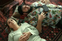 Yusra and Mo lay down on the floor together, their heads on two pillows.