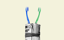 A photo illustration of two toothbrushes sticking out of a roll of cash