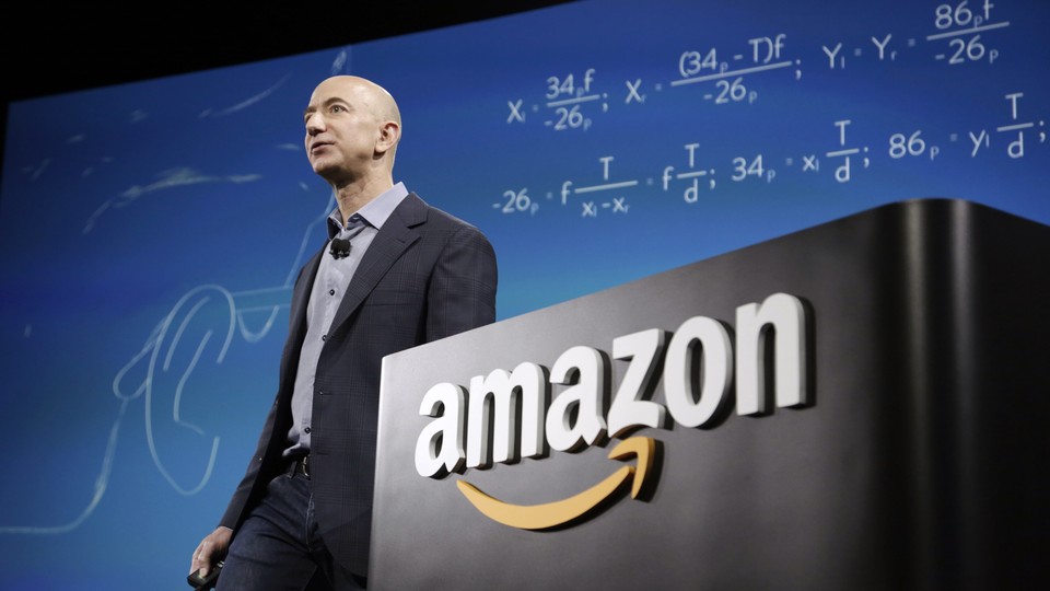 Jeff Bezos standing next to a podium that says "Amazon"