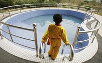 A young boy looks out at a big pool