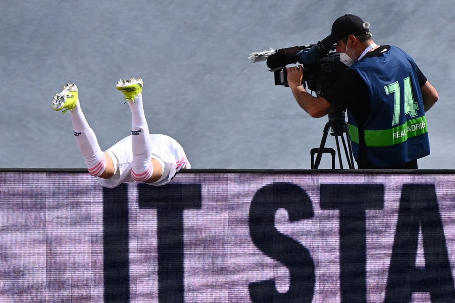 Photos of the Week: Plastic Lake, Van Cat, Burning Judas A soccer player falls over a low fence during a game.