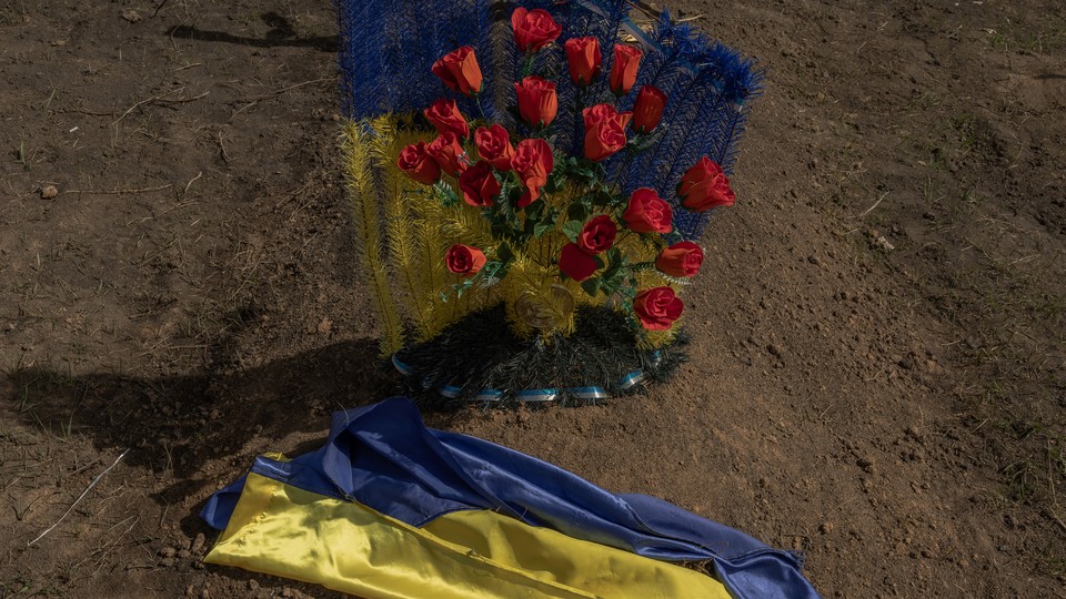 This photograph taken on March 31, 2024, shows a Ukrainian flag on a grave of a victim of the Russian strike that hit a cafe last year, at a cemetery in the village of Groza, Kharkiv region, amid the Russian invasion of Ukraine.