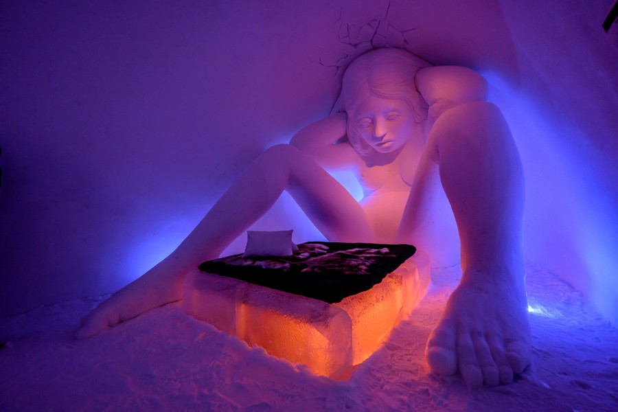 Một tác phẩm điêu khắc tuyết lớn về một người phụ nữ ngồi bên chiếc giường làm từ băng