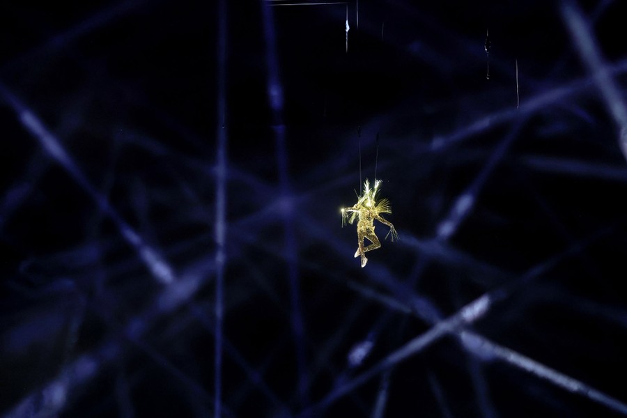 A performer in a golden costume seems to float midair.