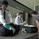 San Francisco International Airport security personnel search through a passenger’s luggage.