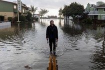 A resident walks along a flooded street after rainstorms slammed northern California, in the coastal town of Aptos, on January 5, 2023