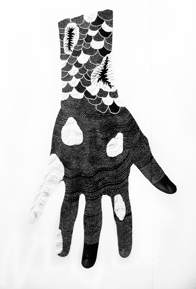 A person's hand in black and white, with fish-like scales covering the wrist