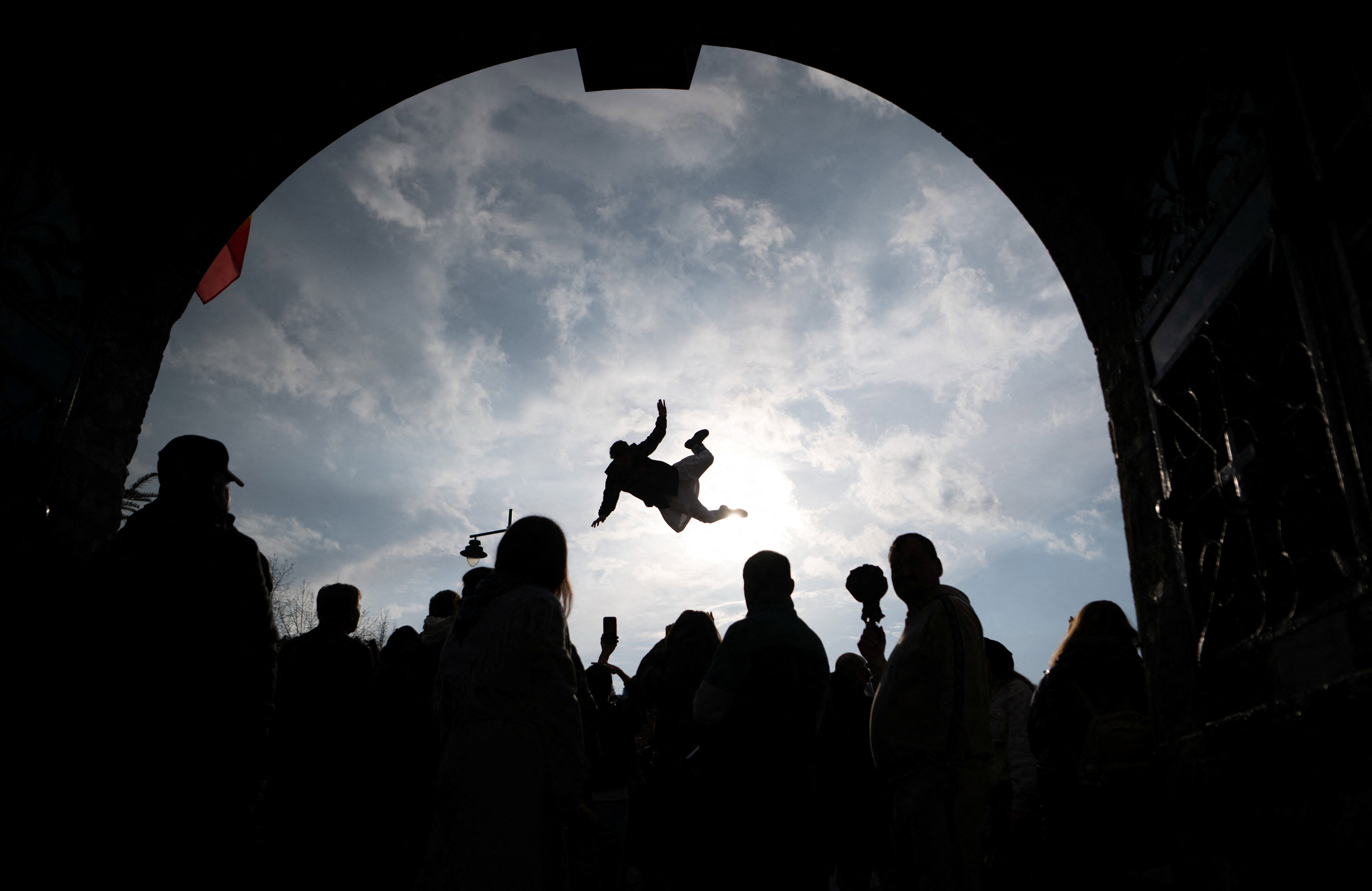 A person is tossed into the air by others using a rug during a festival.