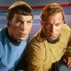 Spock and Captain James T. Kirk lean in to look intently at a screen