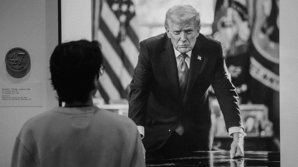 A framed photograph of Donal Trump in a suit, leaning over a table, and a woman looking at it.