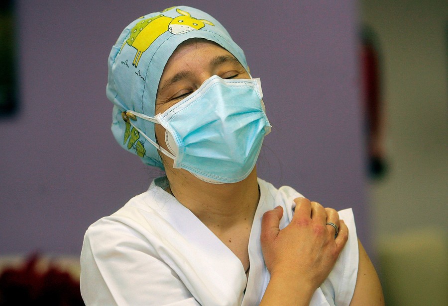 A person reacts after receiving a vaccine dose.