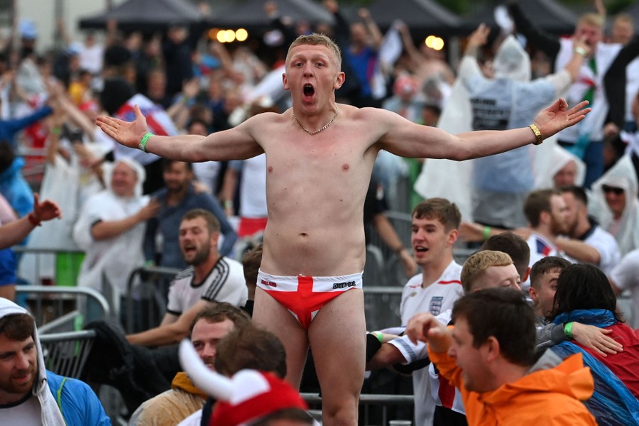 A barely-clothed England fan cheers among others in a fan zone.