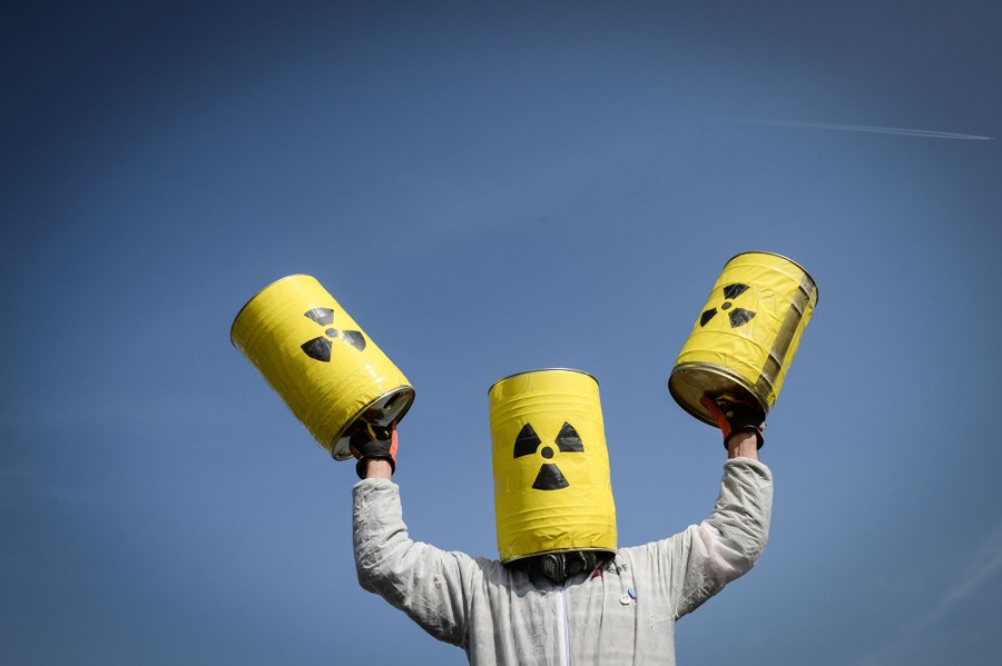 A man carries fake nuclear barrels during a demonstration to demand the closure of Fessenheim nuclear power plant on March 12, 2017, in Fessenheim, eastern France.