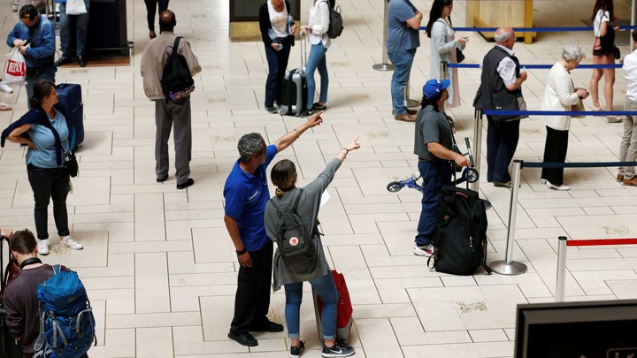 A train attendant and a traveller point at a departure board at the Central Station in Brussels on June 14, 2017.