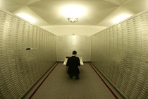 An employee sits amongst safe boxes in a safe room at a Swiss bank