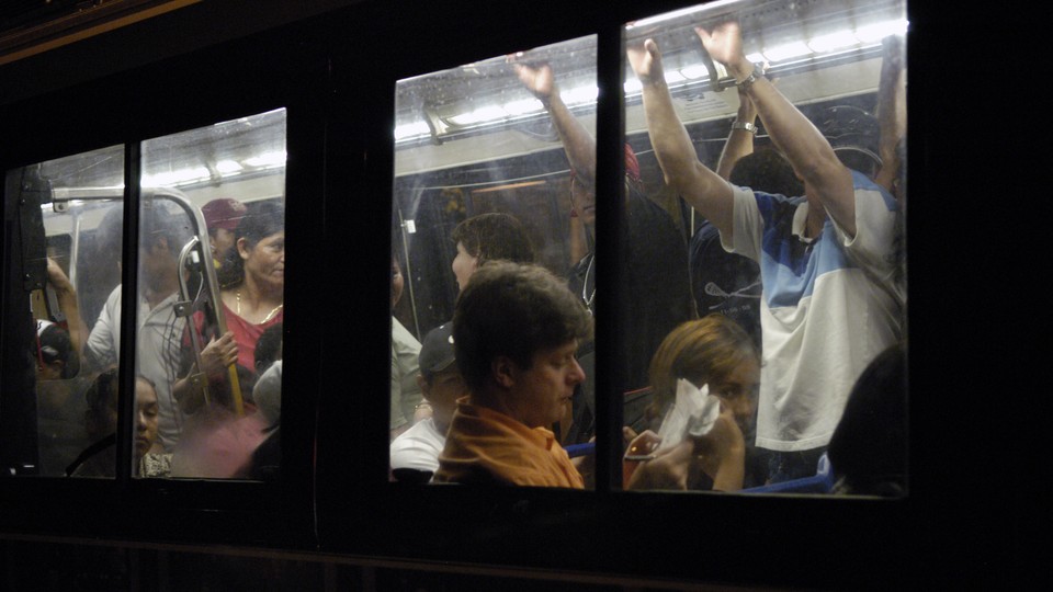 A crowded bus captured from the outside, its many passengers framed by windows
