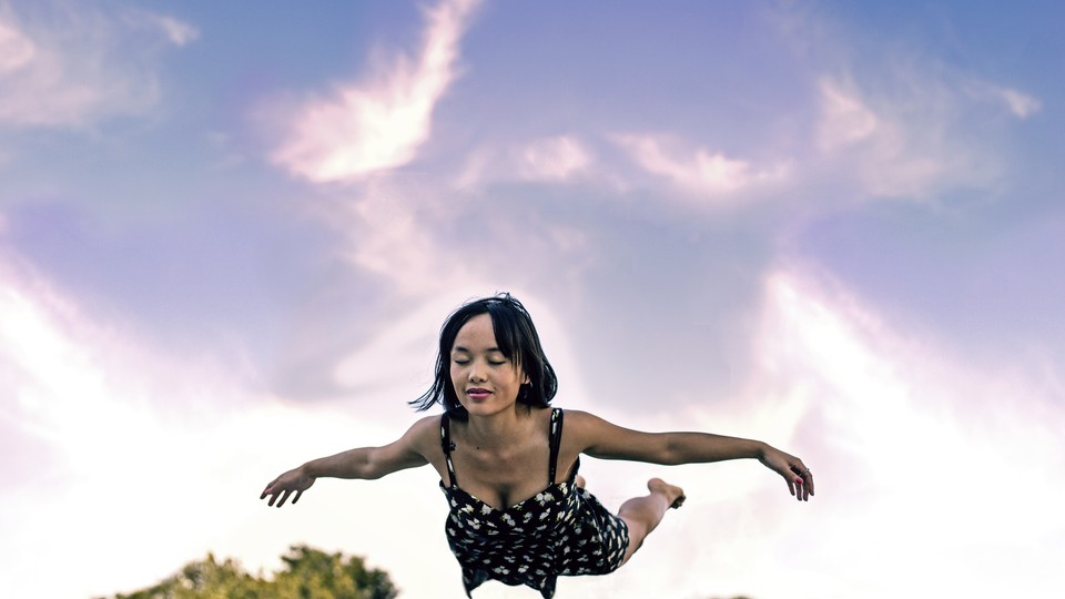 A woman with eyes closed suspended in mid-air