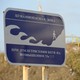 A blue tsunami warning sign on a beach