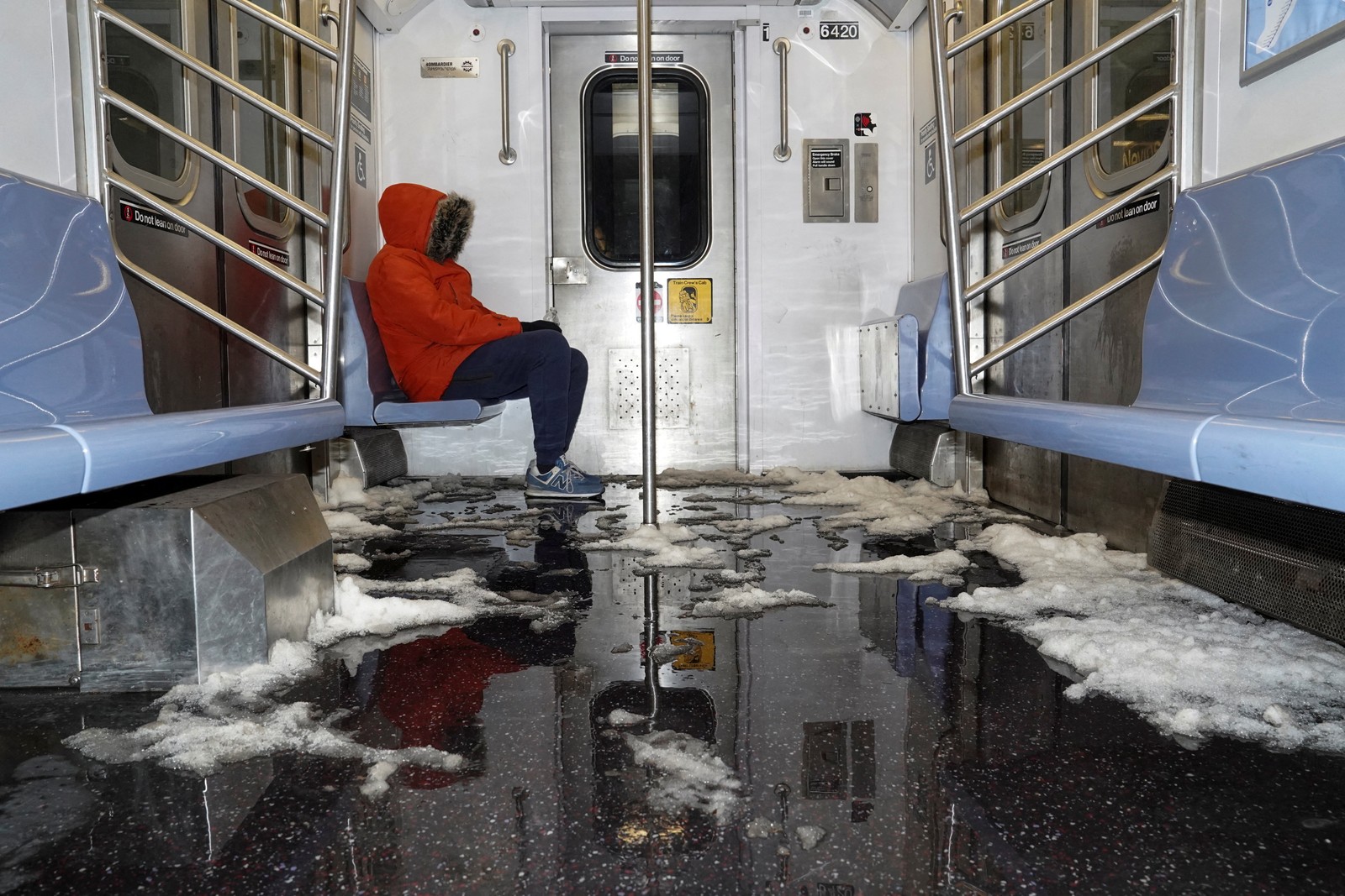 Snow and ice cover the floor of a subway car.