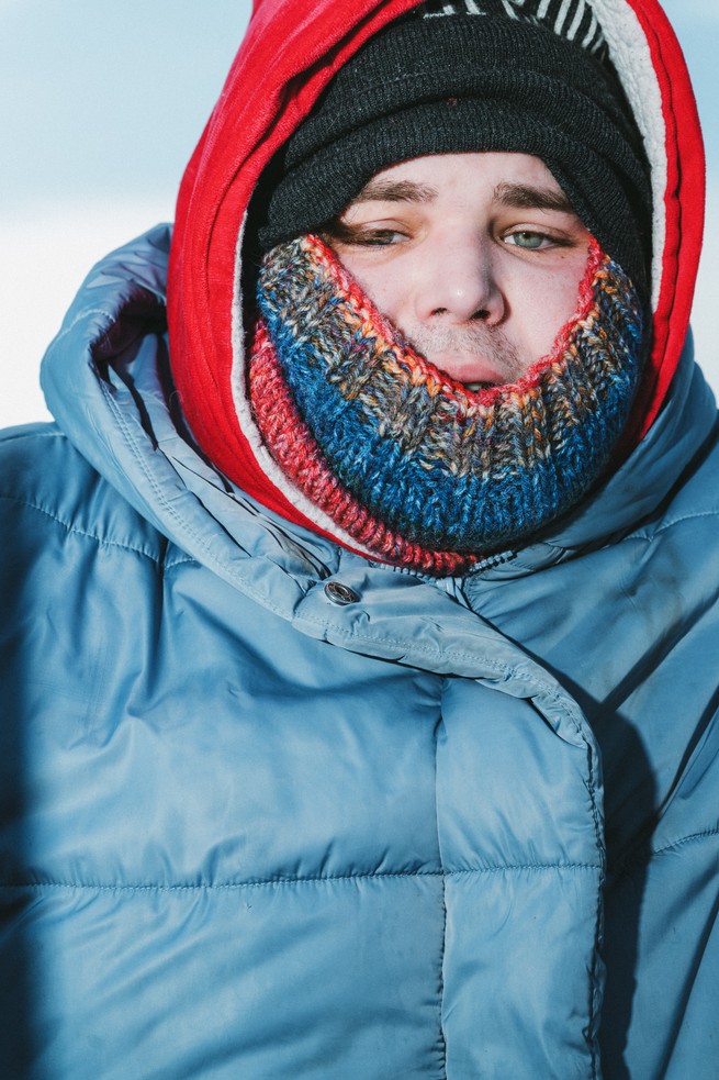 A man bundled up with a weary expression 