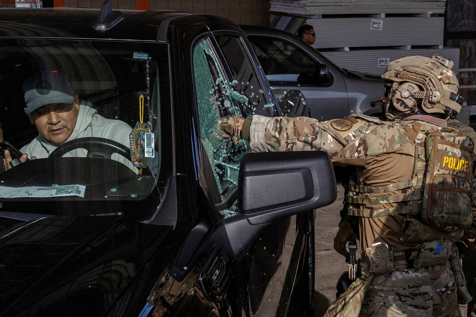 U.S. federal agents smash a car window while trying to detain a man during an immigration raid in Chicago.