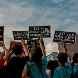 Anti-abortion protesters hold up signs