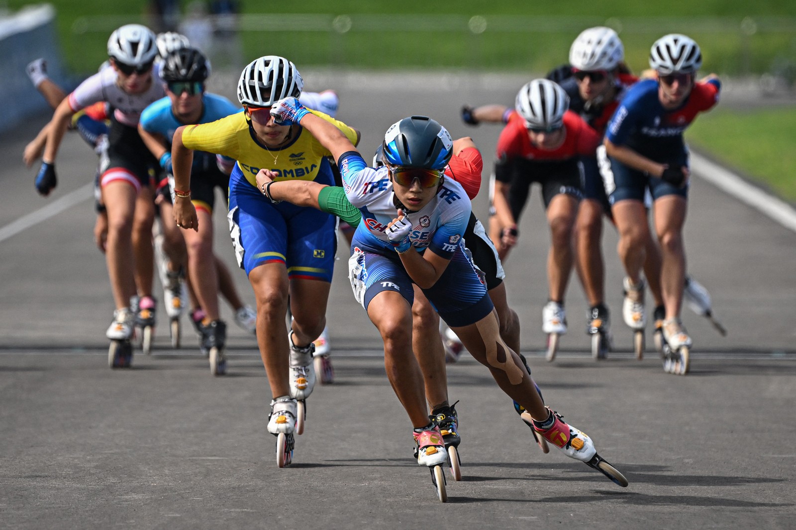 About 10 racers wearing in-line roller blades sprinted toward the camera during a match.