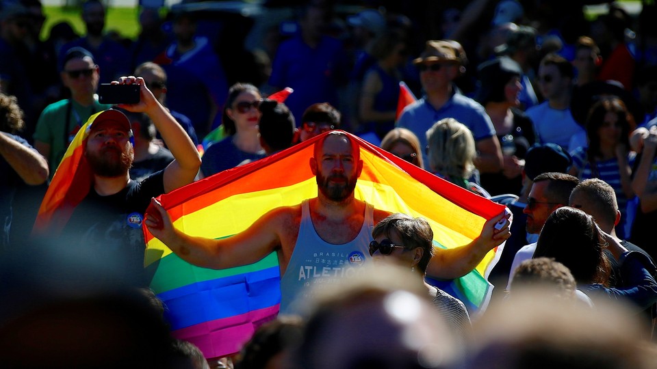 A ‘Yes’ campaign supporter holds a rainbow flag at a rally after it was announced that a majority of Australians support legalizing same-sex marriage at a rally in Sydney, Australia on November 15, 2017.