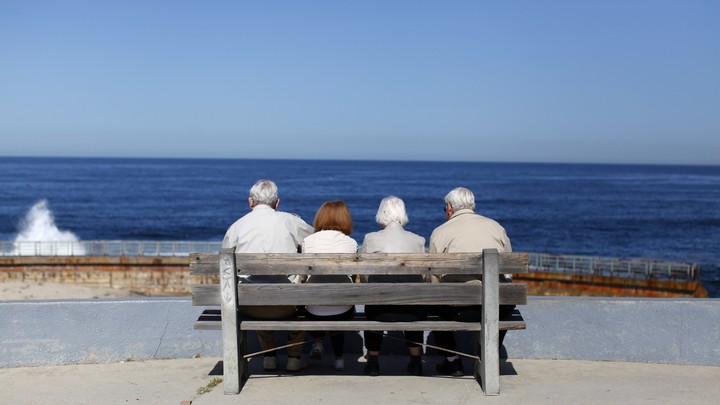 Four elderly people sit on a bench
